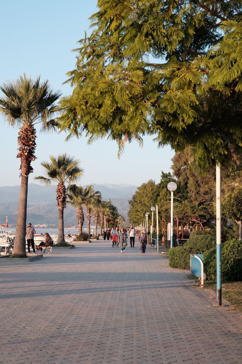 Çalış Plajı'nda gün batımında palmiyeli sahil yürüyüş yolu