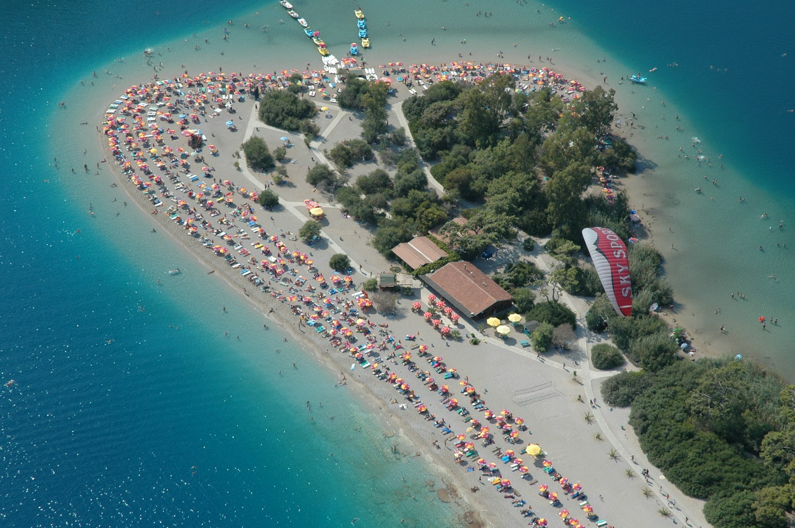 Fethiye Ölüdeniz Kumburnu plajı ve turkuaz lagünün havadan görünümü, yanında yamaç paraşütü