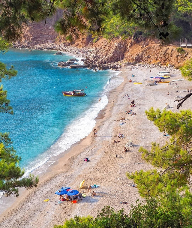 fethiye'ye bağlı kabak koyu ve plajda güneşlenen denize giren insanlar