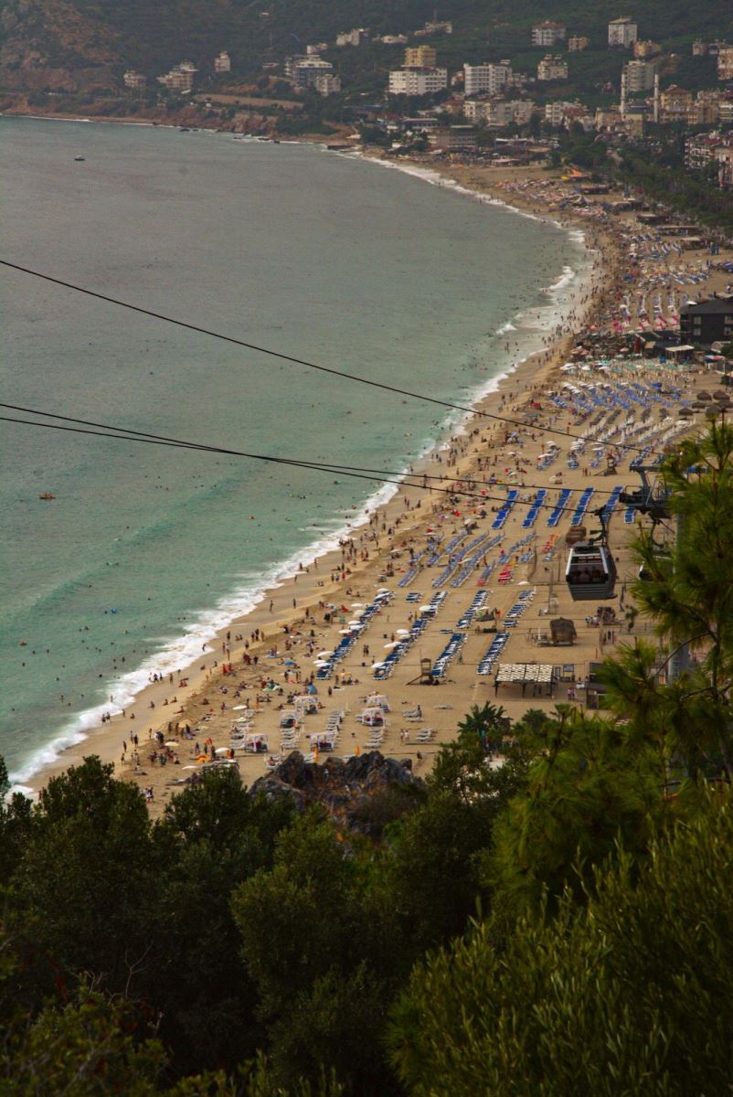 Kleopatra Plajı yaz sezonunda kalabalık şezlong alanı ve Alanya teleferik kabini