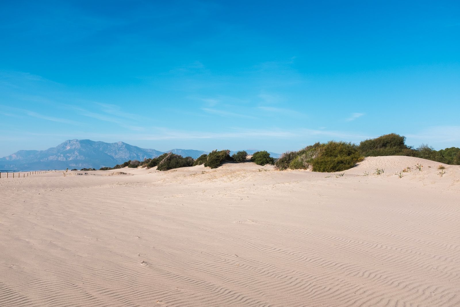 Patara Plajı arkasındaki çöl benzeri doğal kum tepeleri ve dağ manzarası