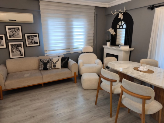 Villa Cozi'nin şık oturma grubu ve yemek alanını bir araya getiren modern salon tasarımı.