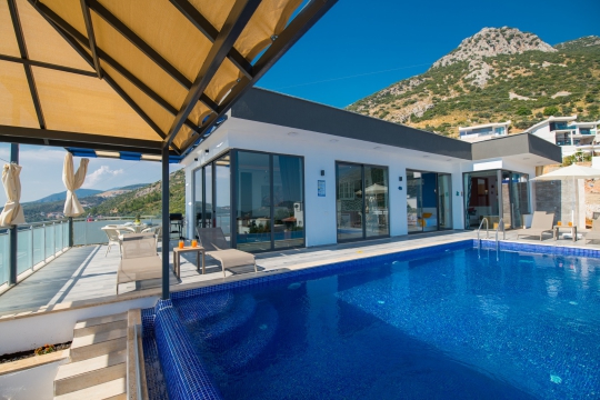 Akbel mevkisinde kiralık Villa Fıstık 1’in deniz manzaralı sonsuzluk havuzu ve şezlongları