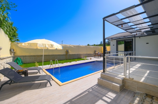 Korunaklı havuzlu Villa Pra 2’nin havuz başı dinlenme alanı