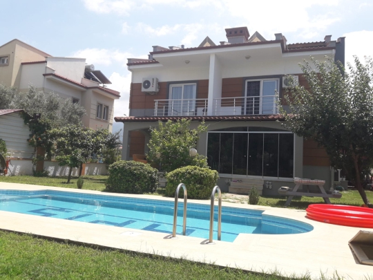 Villa Cozi'nin özel yüzme havuzu ve bahçesiyle geniş ailelere uygun konforlu tatil alanı.
