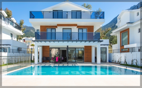 Villa Twins 17’nin modern mimarisi, özel yüzme havuzu ve geniş havuz terasının dağ manzarasıyla buluştuğu ferah dış alan görünümü.