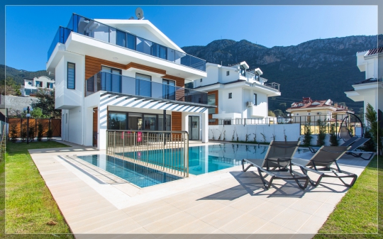 Fethiye Ovacık’ta bulunan Villa Twins 17’nin özel yüzme havuzu, geniş güneşlenme terası, masa ve sandalyelerle düzenlenmiş dış yaşam alanı.