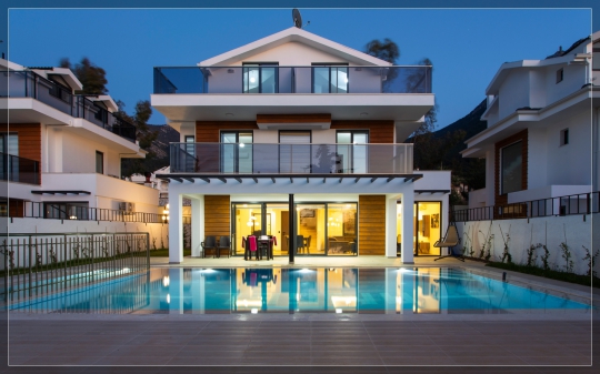 Villa Twins 17’nin akşam saatlerinde aydınlatılan özel yüzme havuzu, modern dış cephesi ve havuz başı dinlenme alanlarının görünümü.