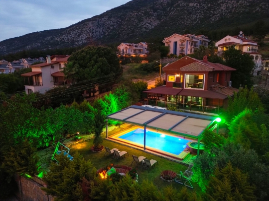 Fethiye Ovacık’ta bulunan Villa Heves 1’in gece konseptli özel havuzu ve lüks bahçe alanını gösteren estetik villa fotoğrafı.