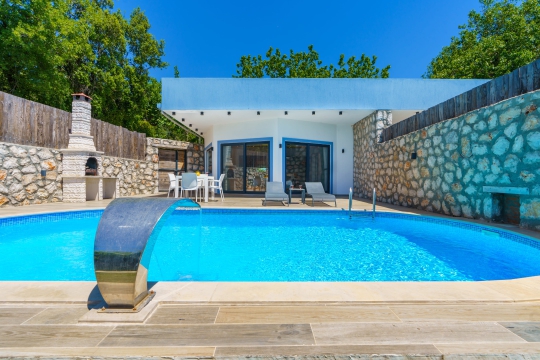 Doğa ile iç içe konumlanan Villa Serter 1’in korunaklı özel havuzu ve modern tasarımlı dış cephesi. Kalkan’da özel havuzlu villa tatili için ideal seçeneklerden biridir.