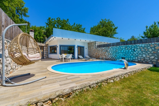 Geniş yüzme havuzu ve ferah güneşlenme alanına sahip Villa Serter 1’in gündüz çekimi. Korunaklı havuzlu villa arayan misafirler için konforlu bir tatil sunmaktadır.
