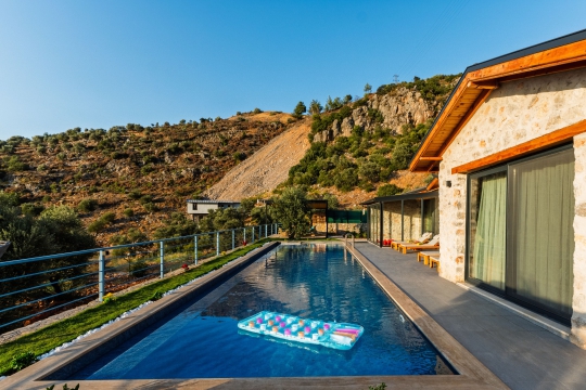 Villa Montana'nın uzun özel yüzme havuzu ve yemyeşil doğa manzarası, sakin ve huzurlu bir villa tatili arayan misafirler için özenle hazırlanmıştır.