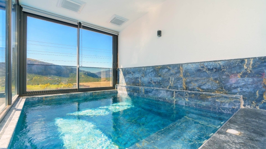Kalkan Villa Sidney 4’ün panoramik doğa manzarasına açılan kapalı yüzme havuzu ve ferah iç havuz alanı.