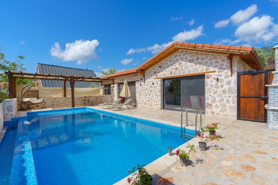 Villa Starlight Kalkan Üzümlü'de geniş özel yüzme havuzu ve modern taş mimarisiyle huzurlu villa tatili sunuyor.