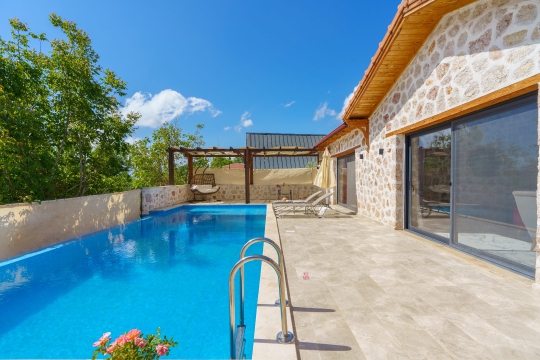 Villa Starlight'ın ferah havuz terası ve korunaklı bahçesiyle Kalkan Üzümlü'de doğa içinde keyifli konaklama.