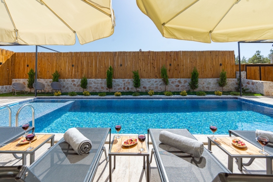 Kalkan Çavdır Villa Enovs’un korunaklı özel yüzme havuzu, şezlongları ve gözlerden uzak modern bahçe alanı.