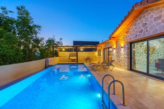 Villa Starlight'ın gece ışıklandırmalı özel havuzu ve doğayla iç içe konumuyla Kalkan Üzümlü'de romantik balayı tatili.