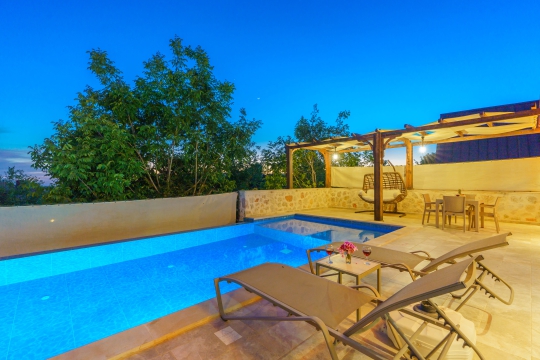 Villa Starlight Kalkan Üzümlü'de özel havuz başında şezlong alanı ve sakin atmosferiyle unutulmaz balayı deneyimi.