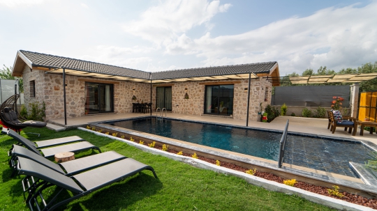 Villa Vira’da korunaklı havuz, şezlong alanı ve konforlu tatil villası detayları