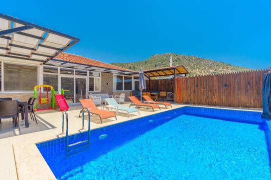 Kalkan Ulugöl Villa Sidney 1’in özel havuzu, şezlongları ve doğayla çevrili sakin dış yaşam alanı.