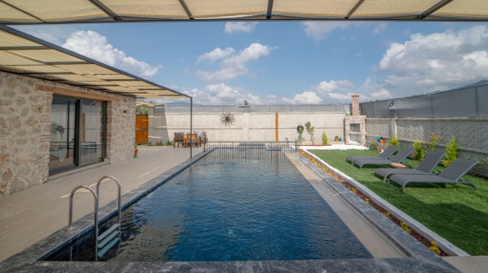 Fethiye’de bulunan Villa Vira’nın geniş özel havuzu ve modern bahçe alanı
