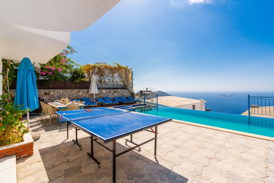 Villa Bonny 2 Kördere’de deniz manzaralı havuz başı masa tenisi alanı ve geniş açık hava yaşam alanı.