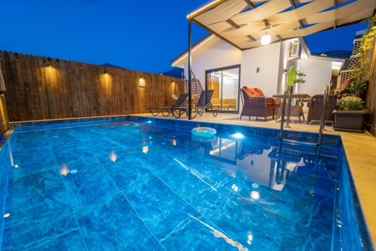 Kalkan Çayköy Villa Rua 1’in özel havuzu, modern veranda alanı ve gece aydınlatmalarıyla romantik balayı tatilleri için ideal bir ortam oluşturuyor.