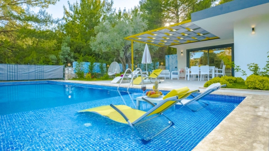 Villa Spada’nın Kalkan İslamlar’daki korunaklı özel yüzme havuzu, şezlong alanı ve doğayla çevrili ferah bahçesinden görünüm.