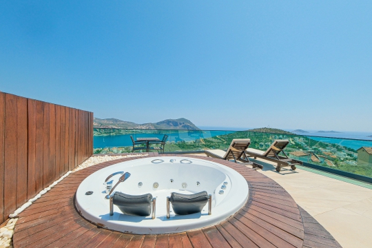 Villa Bika'da Akdeniz manzarasına karşı konumlanan açık hava jakuzisi ile eşsiz bir dinlenme alanı.