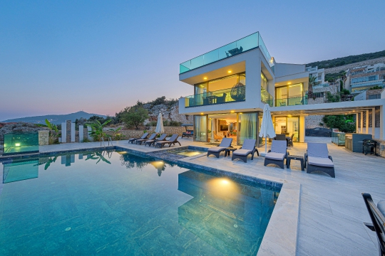Kalkan Ortaalan'daki Villa Bika'nın gün batımında deniz manzaralı özel havuzu ve modern mimarisi.