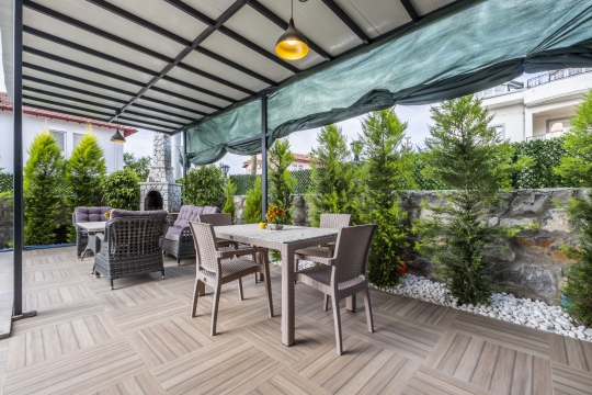 Çisem 3 Villa’nın havuz manzaralı geniş terasında bulunan konforlu yemek masası ve dinlenme alanı.