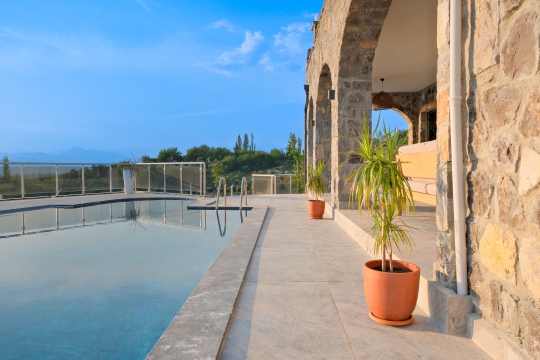 Villa Palace'ın geniş havuz terası ve taş sütunlu veranda alanı.