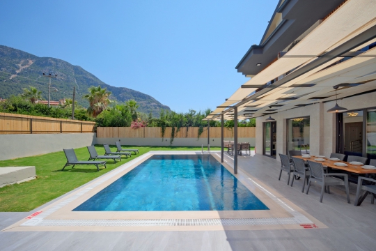Villa Cozy'nin geniş özel yüzme havuzu, güneşlenme alanı ve ferah bahçesiyle konforlu villa tatili.