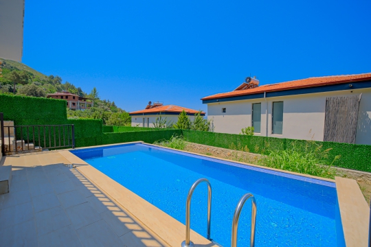 Villa Mino'nun geniş özel yüzme havuzu, güneşlenme alanı ve doğayla iç içe konumuyla huzurlu tatil atmosferi.