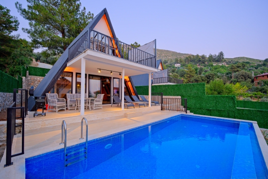 Üzümlü'de bulunan Villa Mino'nun özel havuzu, geniş terası ve modern bungalov mimarisiyle lüks tatil deneyimi.
