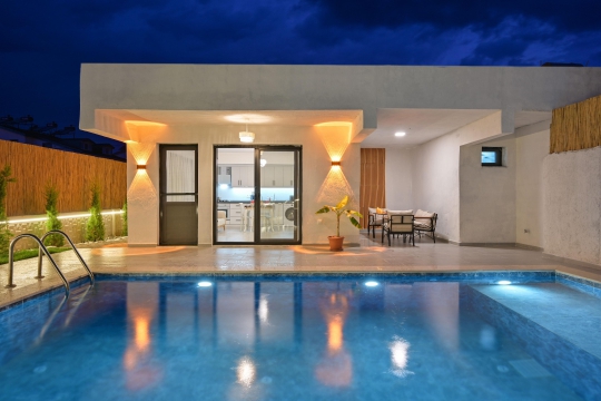Villa Leon’un geniş havuz terası ve modern dış mimarisiyle ailelere uygun korunaklı tatil villası atmosferi.