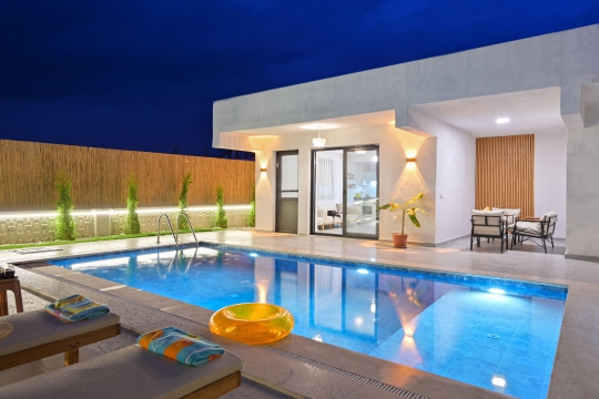 Villa Leon’un akşam aydınlatmalı özel yüzme havuzu ve modern mimarisiyle Seydikemer’de huzurlu kiralık villa deneyimi.