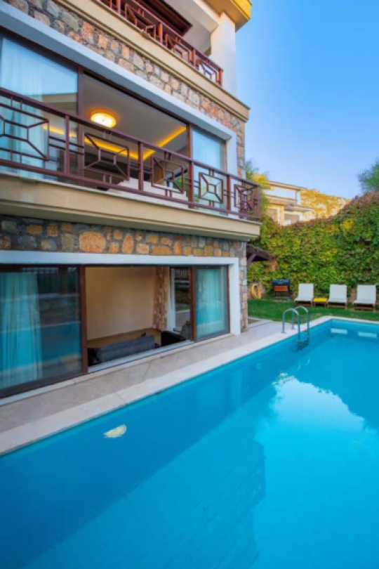 Villa Eleas Duo’nun özel havuz alanı ve taş mimarili dış cephesi; Fethiye Göcek’te jakuzili, 10 kişilik kiralık villa.
