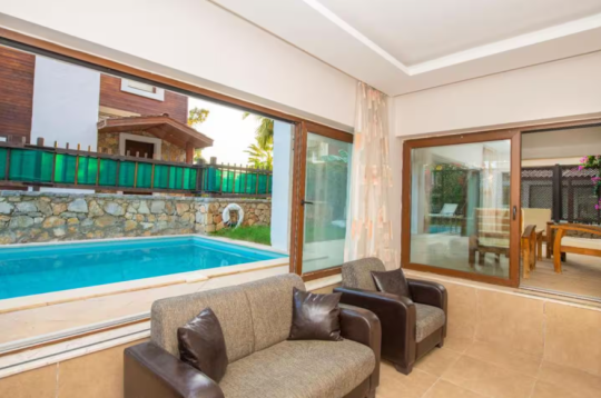 Villa Eleas Duo’nun havuz manzaralı açık oturma alanı; Fethiye Göcek’te doğayla iç içe, konforlu villa tatili.