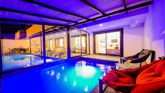 Villa Sidney 3’ün gece aydınlatmalarıyla öne çıkan özel yüzme havuzu ve modern dış yaşam alanı.