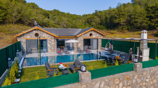 Villa New Star 2'nin özel havuzu, güneşlenme alanı ve doğa manzarasıyla huzurlu aile tatili imkânı.