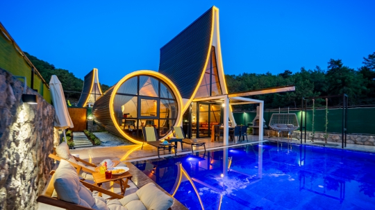 Villa Sunny 1'in akşam ışıklarıyla büyüleyici görünümü, özel havuzu ve modern A-frame tasarımı.