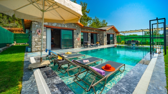 Villa Nimo Duo'nun korunaklı bahçesi, özel yüzme havuzu ve açık hava yemek alanı gözlerden uzak tatil isteyen misafirler için idealdir.