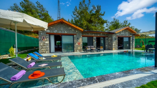 Fethiye Çalış'taki Villa Nimo Duo'nun özel yüzme havuzu, geniş veranda ve açık yemek alanı keyifli tatil anları yaşatmaktadır.