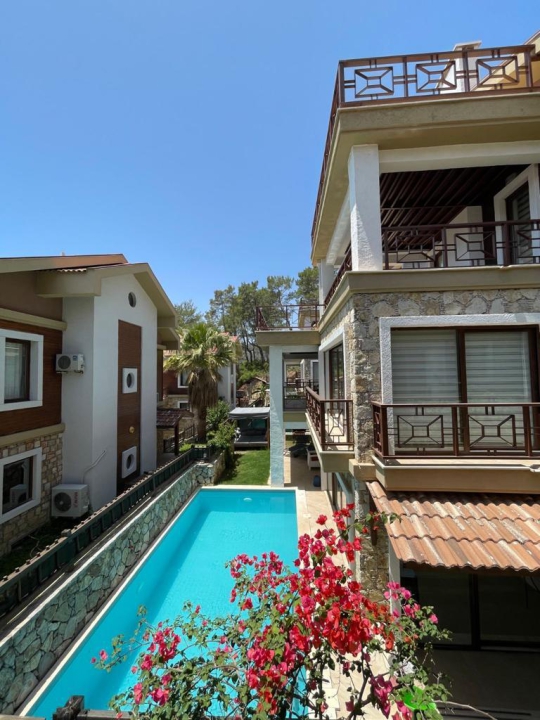 2. Villa Eleas’ın özel havuz alanı ve dış cephe görünümü; Göcek’te korunaklı havuzlu, geniş bahçeli ve 10 kişilik kiralık villa.