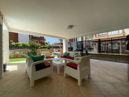 Villa Eleas’ın ferah oturma alanı ve geniş cam cepheli salonu; Fethiye Göcek’te doğayla iç içe konforlu villa tatili.