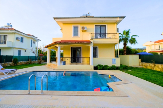 Villa Beta’nın 6 x 4 metre özel yüzme havuzu, dubleks villa dış cephesi ve havuz başı dinlenme alanı.