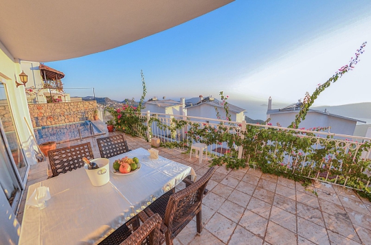 Villa Cotto’nun deniz manzaralı geniş terasında masa ve sandalyeler bulunmakta, açık havada keyifli vakit geçirme imkânı sunulmaktadır.