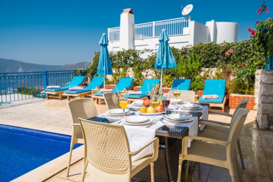 Villa Veronica’nın havuz başı yemek alanı, özel yüzme havuzu ve şezlonglarıyla aile ve arkadaş grupları için ferah bir tatil alanı sunmaktadır.