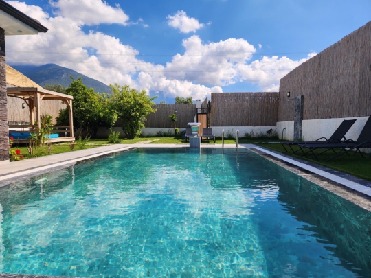 Fethiye kiralık villa için drone ile havadan çekilmiş tam korunaklı havuz ve bahçe alanı